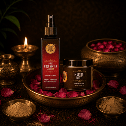 Shesha Ayurveda Pure Rose Water and Multani Mitti displayed in a traditional Ayurvedic setting with brass bowls, rose petals, herbal powders, and a glowing oil lamp. The products are arranged on an antique brass tray against a warm, dark background, highlighting natural skincare inspired by authentic Ayurvedic traditions.